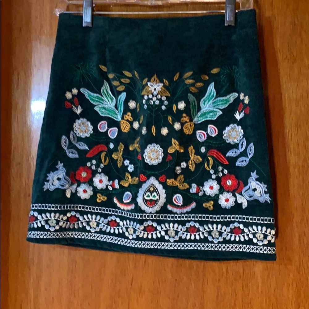 Corduroy mini skirt with floral stitching.